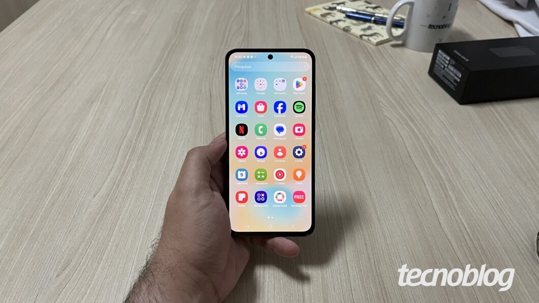 Mão segurando Galaxy S24 FE na tela de aplicativos