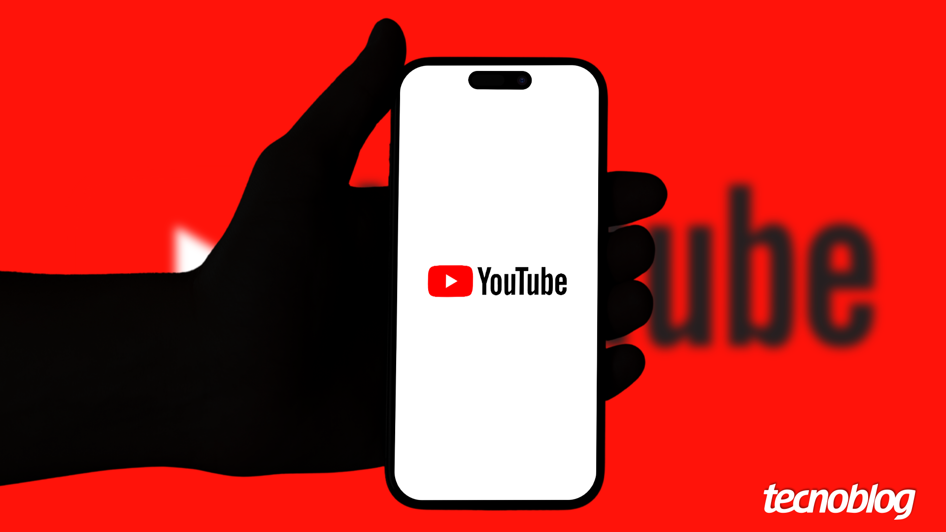 Mão segurando um celular que exibe o YouTube, com um fundo de cor vermelha. Na parte inferior direita, está o logotipo do "tecnoblog".