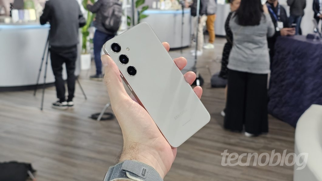 Mão segurando smartphone, mostrando a parte traseira