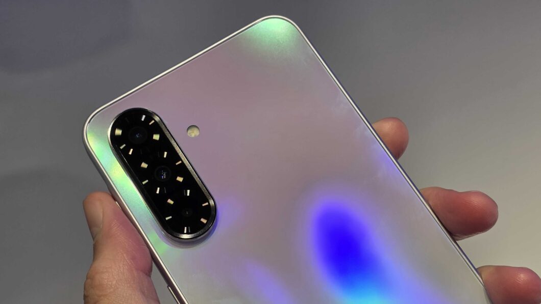 Mão segurando o Galaxy A36 com a câmera tripla para cima