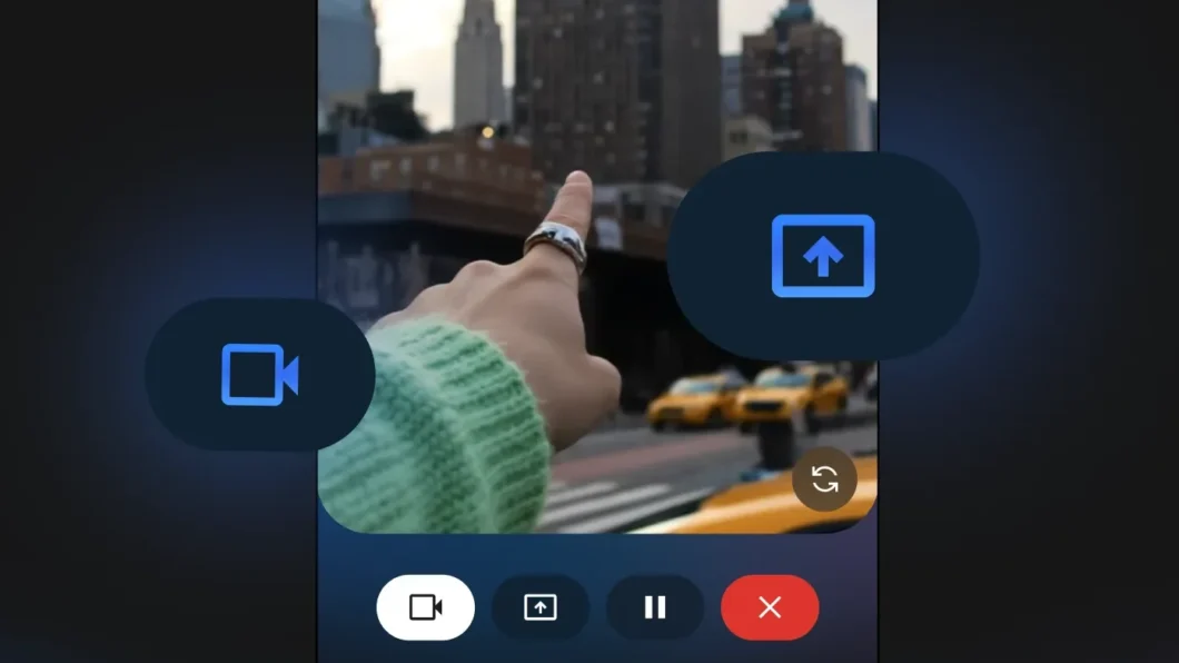 Tela de celular mostrando o recurso Gemini Live, um aplicativo de IA que permite transmitir vídeos ao vivo para a inteligência artificial analisar. A imagem mostra uma mão com suéter verde apontando para prédios e táxis amarelos em uma cidade. Na parte inferior há ícones para câmera, compartilhamento de tela, pausa e encerramento da transmissão, com fundo escuro e iluminação azul e roxa.
