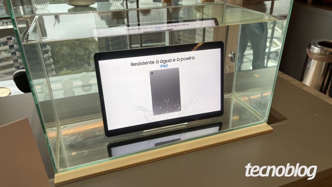 Galaxy Tab S10 FE em um áquario. A tela mostra o texto "Resistente à água e à poeira; IP68"