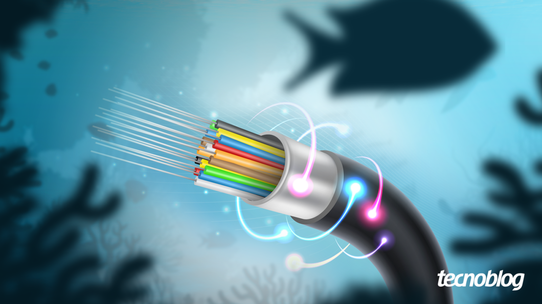 Imagem mostra uma seção transversal de um cabo de fibra óptica em um ambiente submarino. O cabo, em tons escuros, revela internamente múltiplos fios coloridos: azul, amarelo, vermelho, verde, marrom e outros. Alguns desses fios emitem luzes azuis, rosas e brancas, formando feixes luminosos. Ao fundo, silhuetas de peixes e corais, com o logotipo do "tecnoblog" no canto inferior direito.
