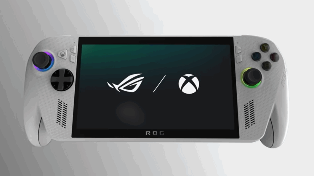 Imagem em plano central de um console de videogame portátil, tipo PC gamer, na cor branca e cinza. O console tem uma tela central que exibe um fundo escuro com o logotipo da ROG (Republic of Gamers) e o logotipo do Xbox lado a lado, separados por uma barra. Na parte inferior da tela, está o texto "ROG"
