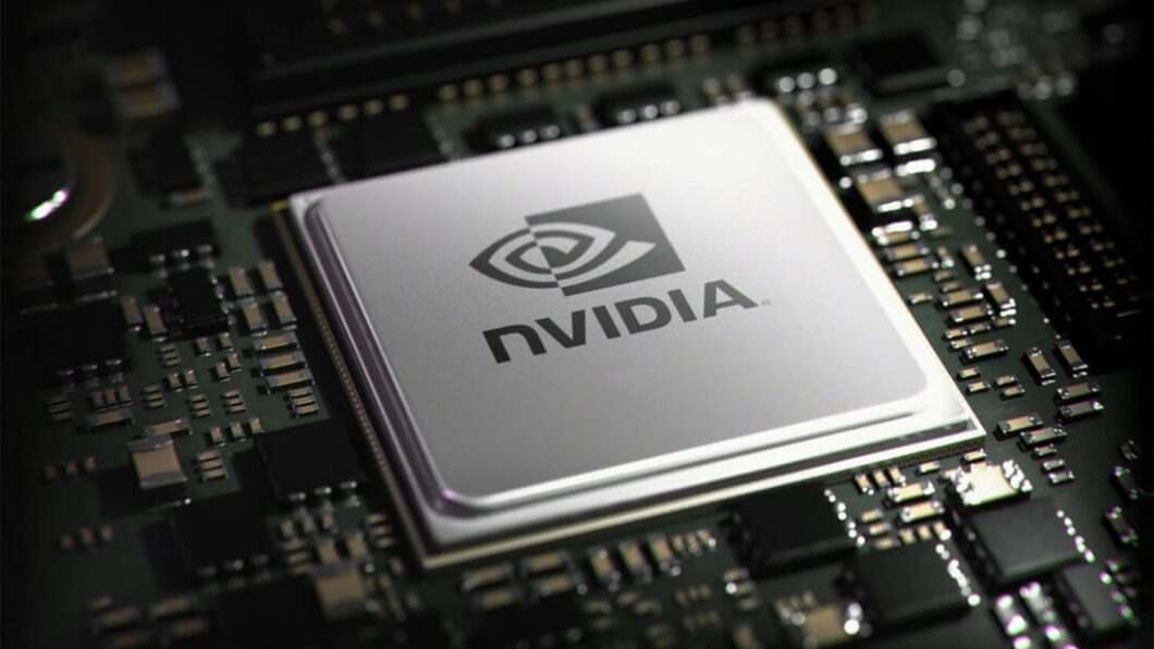 Imagem mostra um chip de computador prateado, com o logo e o nome "NVIDIA" em preto, centralizado em uma placa-mãe escura cheia de pequenos componentes eletrônicos.