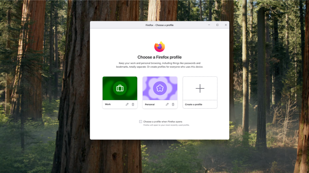 Janela do navegador Firefox exibe a tela “Choose a Firefox profile”, com opções de perfis separados para uso. Três cartões aparecem: “Work”, com ícone de mala em fundo verde; “Personal”, com ícone de flor em fundo lilás; e “Create a profile”, com símbolo de adição. O fundo mostra uma floresta com árvores altas e luz natural.