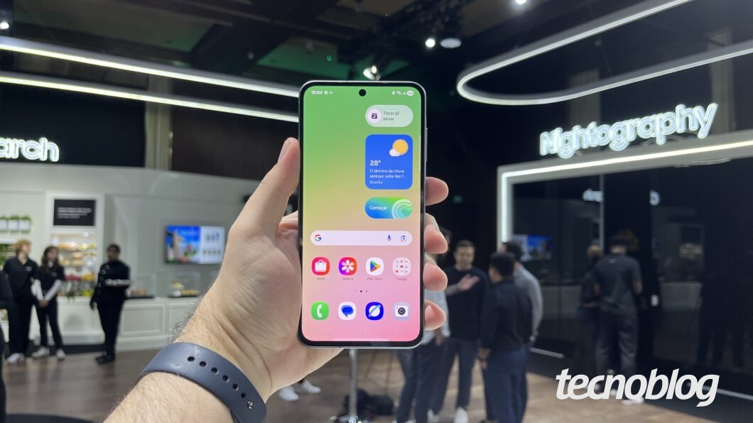 Foto de smartphone na tela inicial, com ícones de apps e widgets