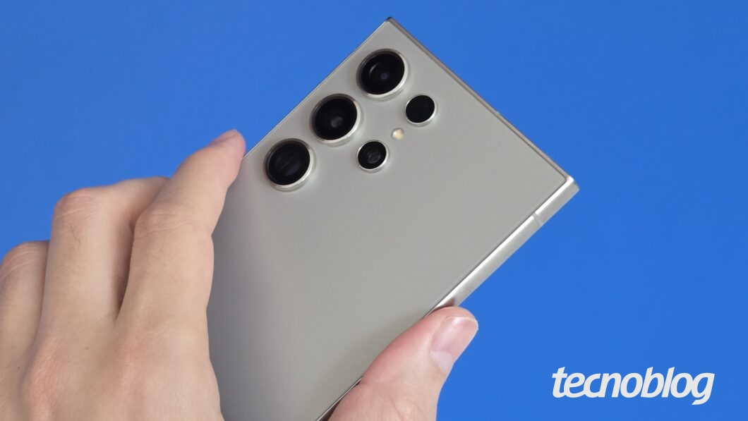 Mão segurando smartphone, visto de trás