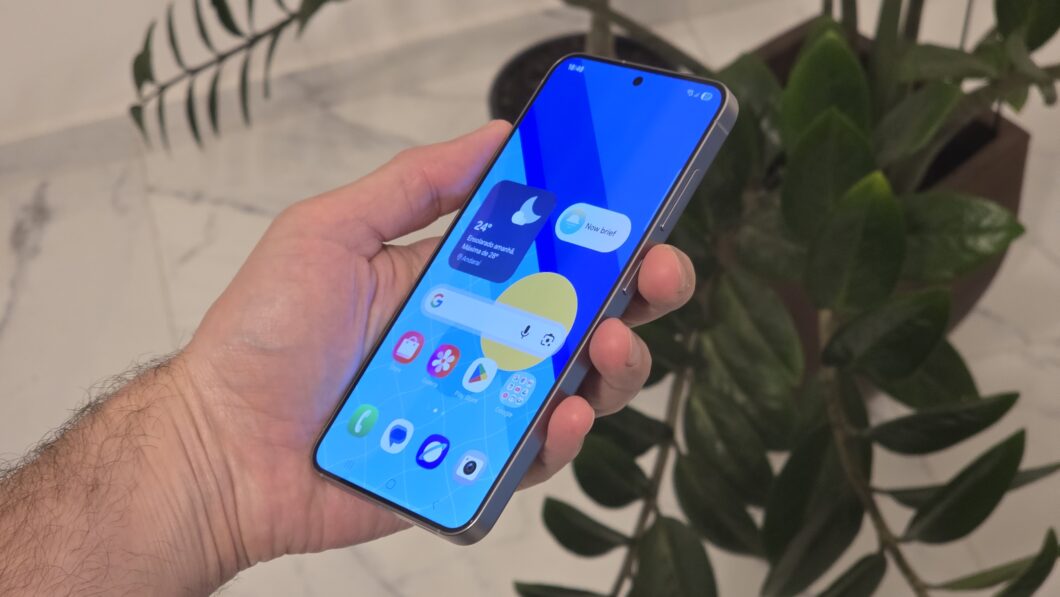Mão segurando o Galaxy S25, mostrando a tela do celular