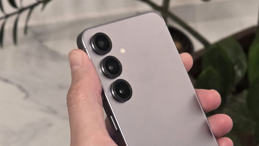 Mão segurando o Galaxy S25, mostrando a traseira com as câmeras