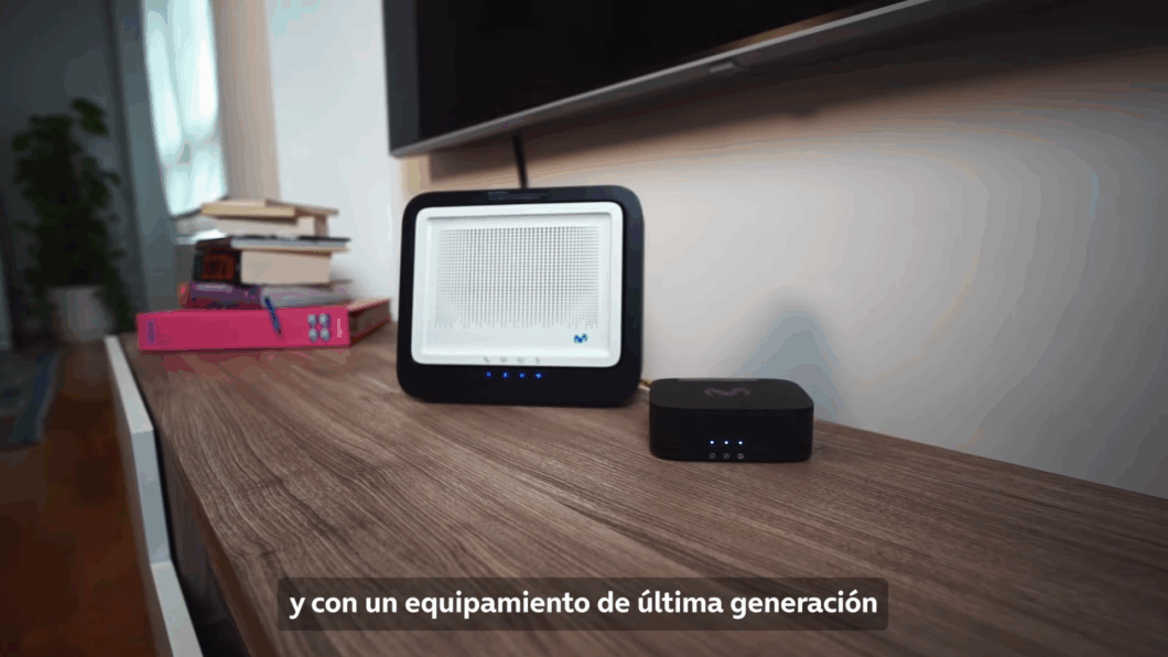Escrivaninha contendo modem de fibra óptica e equipamento para fibra FTTR, com legenda em espanhol