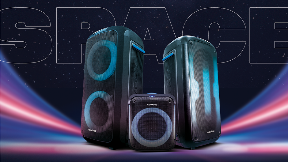 Exibição de três caixas de som portáteis da marca Aquario com luzes LED. O conjunto é composto por dois modelos maiores e um modelo compacto, todos com a grade frontal em preto. As luzes circulares dos woofers estão acesas em um tom de azul neon. O fundo escuro possui uma faixa de luz colorida (rosa, roxo e azul) e a palavra "SPACE" estilizada no topo.