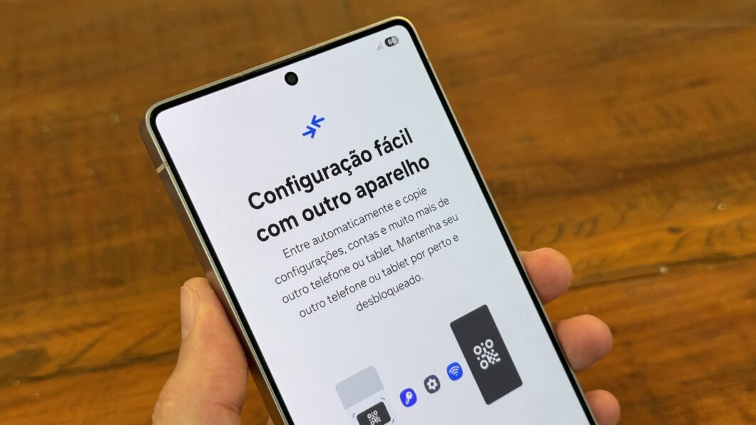 Mão segurando Galaxy S25 Ultra com tela mostrando facilidade de configuração com outro aparelho. 