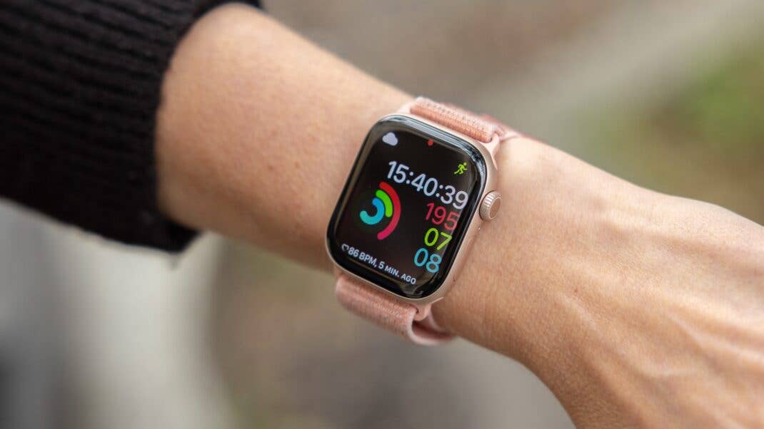 A close-up of an Apple Watch displaying time and fitness metrics on a wrist.