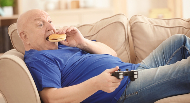 man eating junk food on the sofa