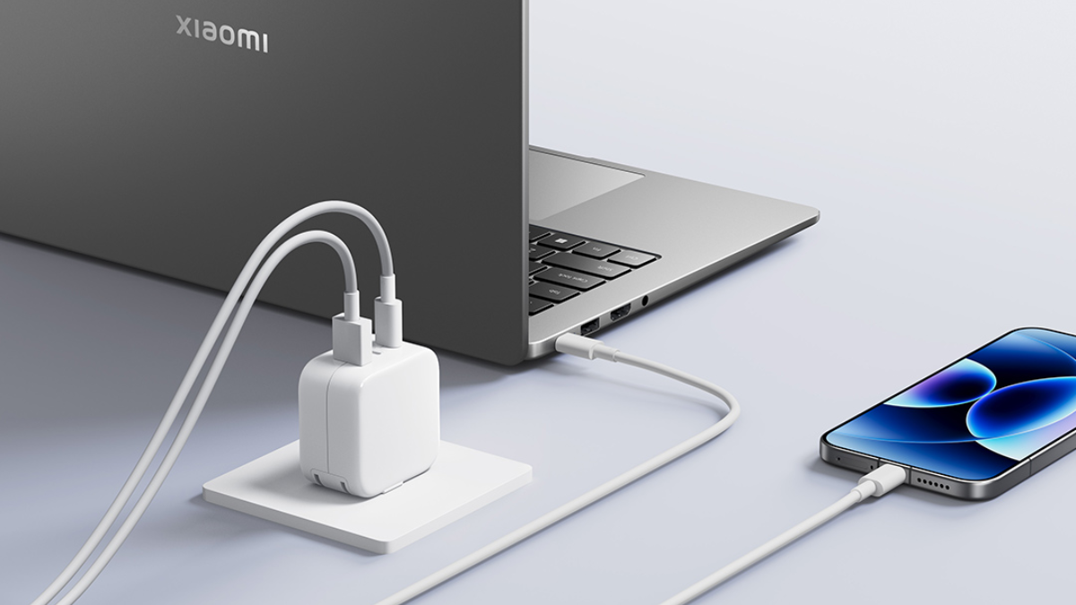 Imagem mostra um carregador branco da Xiaomi carregando um smartphone e um notebook.