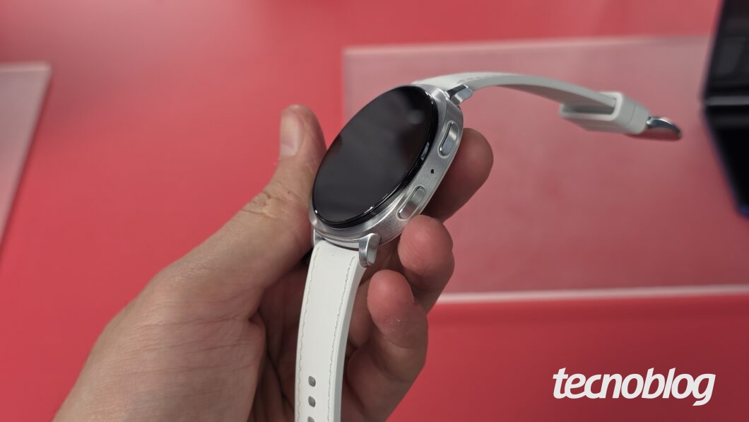 Mão segurando smartwatch com tela desligada