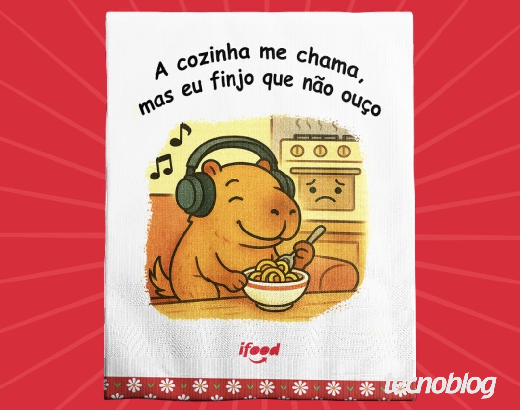 Ilustração em estilo de pano de prato do iFood com o texto “A cozinha me chama, mas eu finjo que não ouço”. Uma capivara usa fones de ouvido e come macarrão sorrindo, enquanto um fogão ao fundo aparece com expressão triste. O fundo é branco com borda decorada e o logo do iFood na parte inferior.