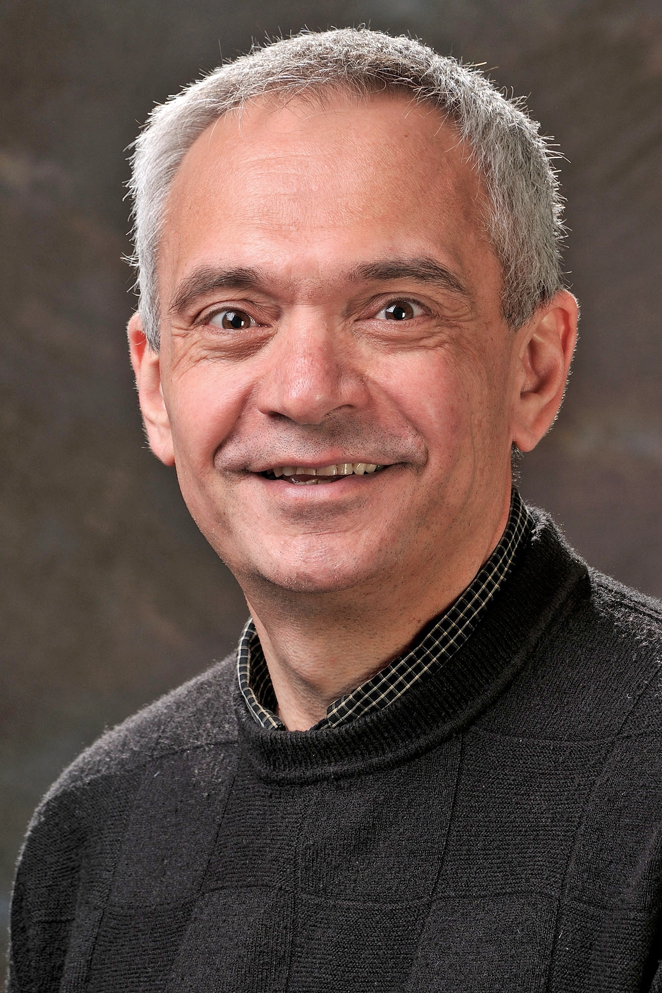 Smiling man with close-cropped gray hair.