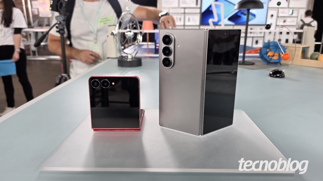 Dois smartphones dobráveis parcialmente dobrados sobre uma mesa, vistos de trás