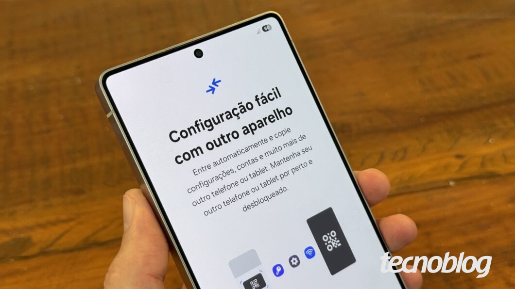 Mão segurando Galaxy S25 Ultra com tela mostrando facilidade de configuração com outro aparelho.