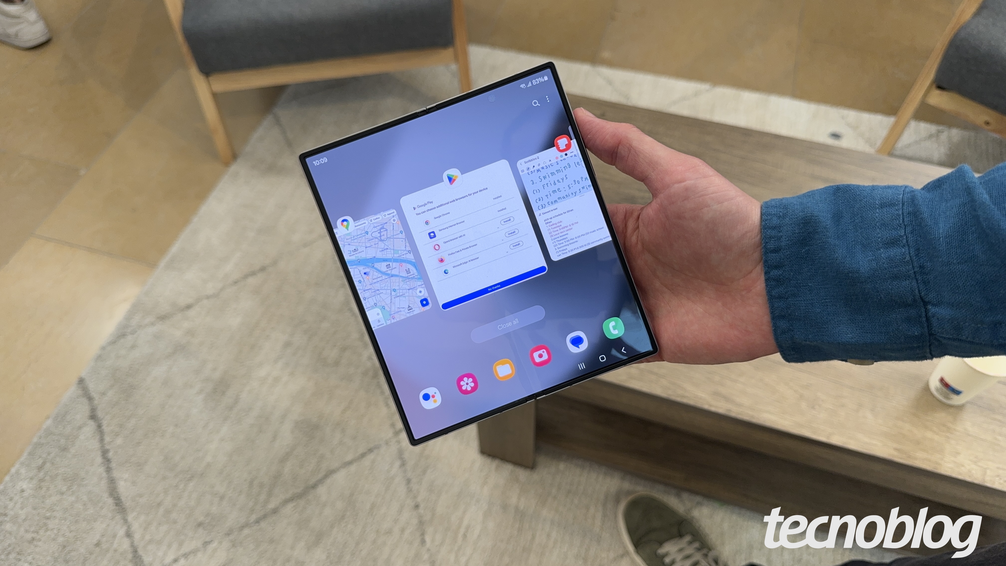 Mão segurando smartphone dobrável aberto