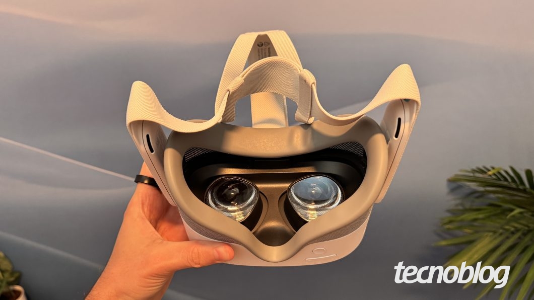 Meta Quest 3S sendo segurado em uma mão. Na parte inferior direita, a marca d'água do "tecnoblog" é visível.