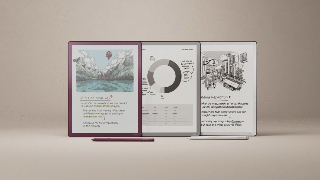 Três tablets Kindle Scribe Colorsoft posicionados lado a lado sobre fundo neutro. As telas exibem conteúdo colorido: à esquerda, uma ilustração de paisagem com montanhas e balão, acompanhada do texto “Notes on creativity”; ao centro, um gráfico circular com percentuais e anotações manuscritas; à direita, um desenho urbano em preto e branco com o título “Finding inspiration” e parágrafos de texto. Duas canetas stylus repousam à frente dos aparelhos.
