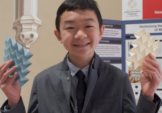 miles wu holding two sheets of origami