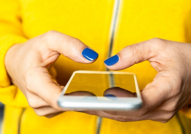 person in a yellow jacket holding a phone