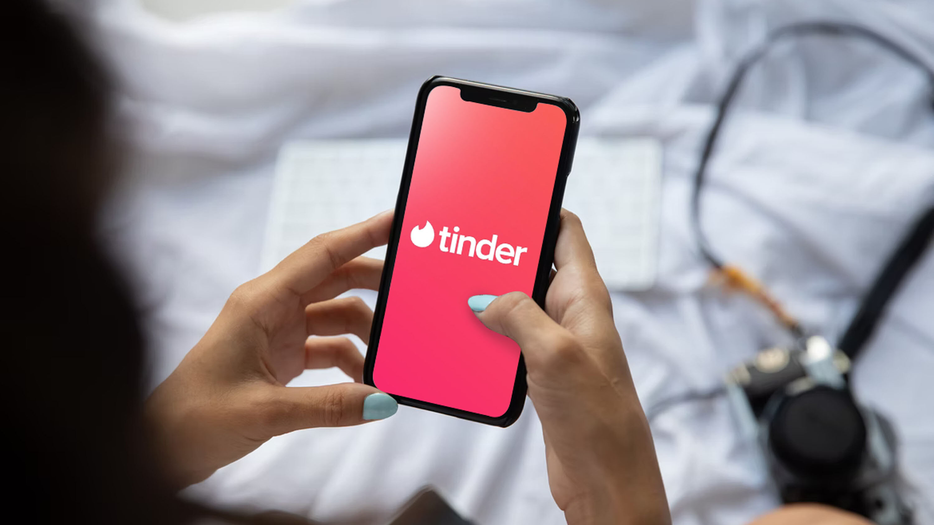Imagem de um celular na tela de abertura do Tinder
