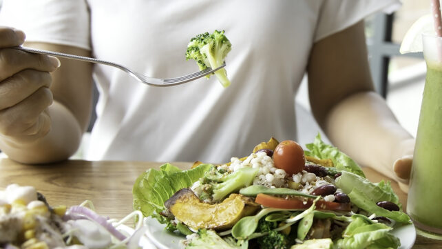 Selective focus of woman with broccoli and salad