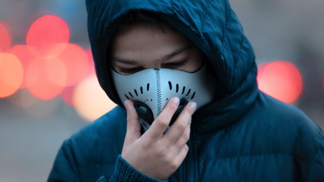 Young person wearing a mask in a high traffic area