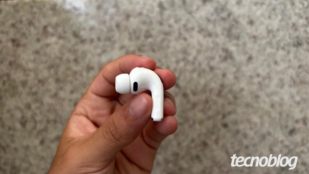 Uma mão segurando um dos fones AirPods Pro 3 lateralmente