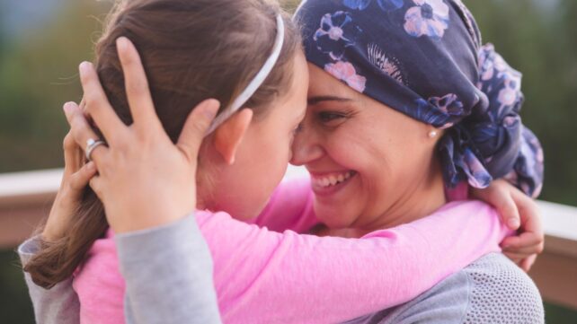 Woman hugging her daughter after recovering from cancer