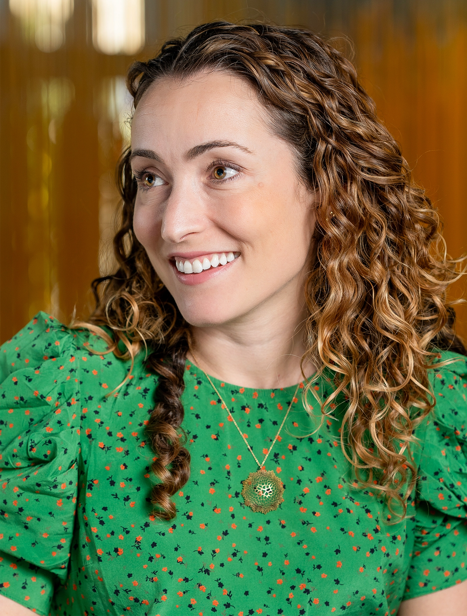 A woman with curly hair in a green shirt.