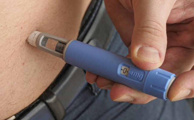 semaglutide pen injecting into a person's abdomen