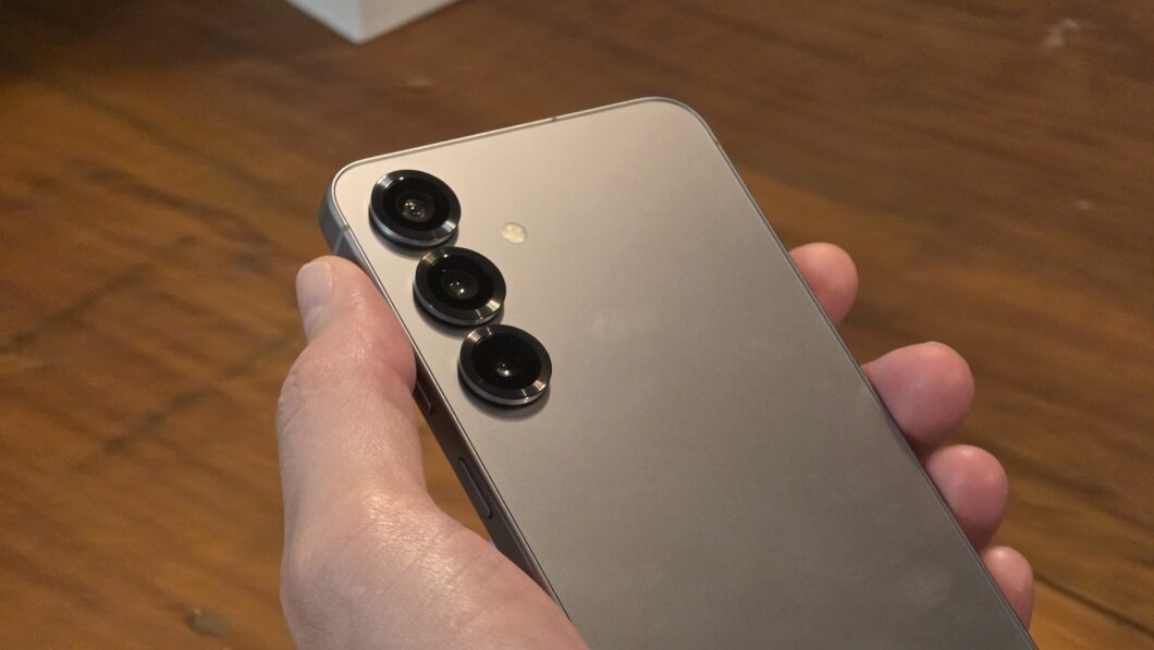 Mão segurando o Galaxy S25, mostrando a traseira com as câmeras