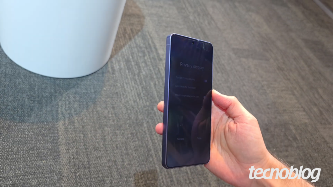 Galaxy S26 Ultra visto de lado. A tela está bastante escurecida, impedindo que pessoas ao lado vejam o conteúdo.