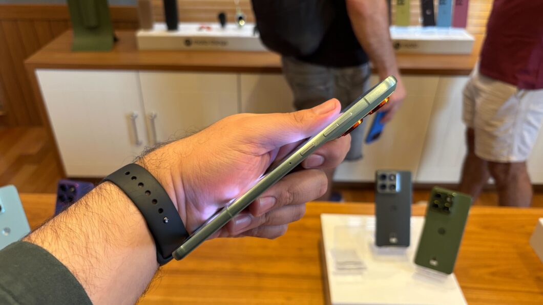 Motorola Edge 70 sendo visto lateralmente e segurado por uma mão com um relógio no pulso