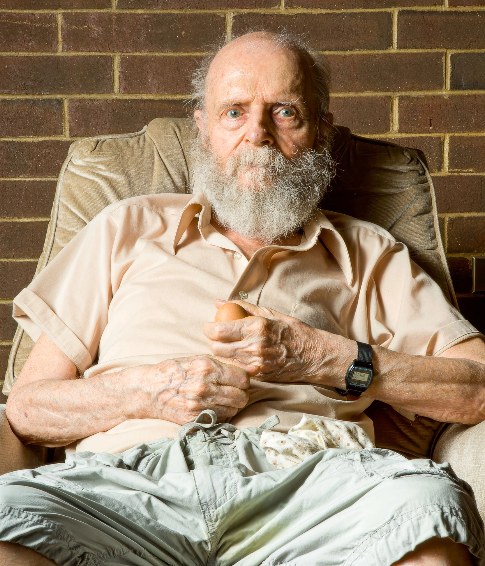 Bearded man sitting in a chair.