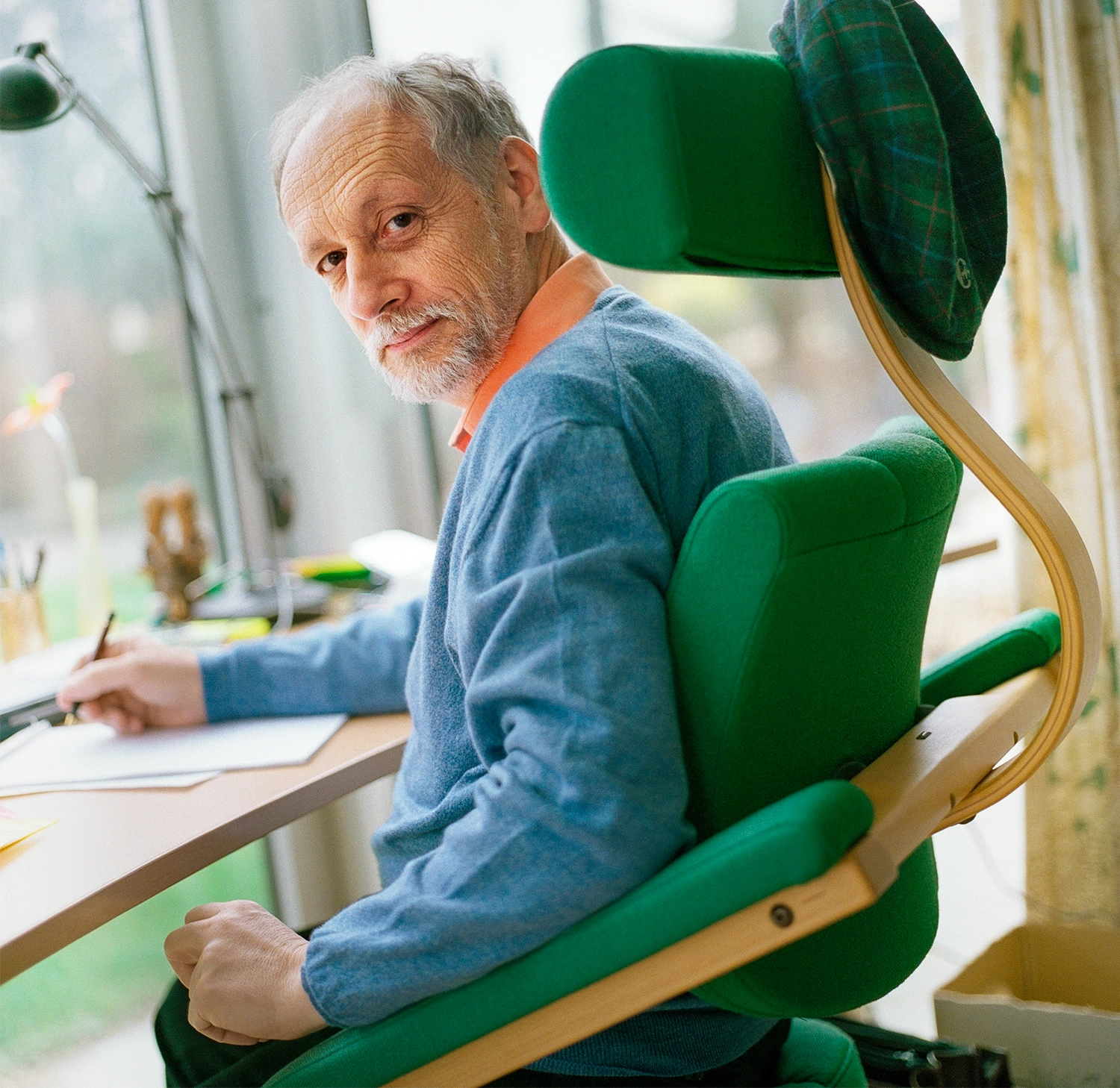 Man sitting in a green chair at a desk.