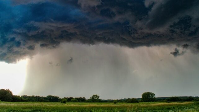 Storm cloud over an open green area 