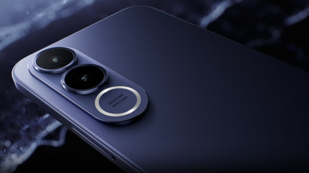 Foto em close da parte traseira de um smartphone azul-escuro com acabamento fosco. O destaque é o módulo de câmeras triplas, dispostas verticalmente em uma base oval saliente. As duas lentes superiores são pretas e profundas. A terceira lente, na base, é cercada por um anel prateado brilhante, contendo a inscrição "200MP OIS CAM"