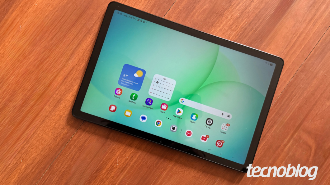 Galaxy Tab A11 Plus com tela acesa exibindo ícones de aplicativos sobre mesa de madeira