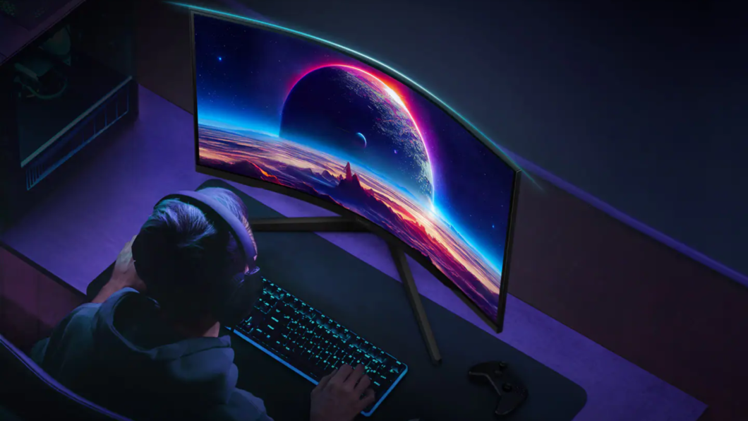 Homem sentado em uma cadeira usando o Monitor Odyssey G5 apoiado sobre uma mesa