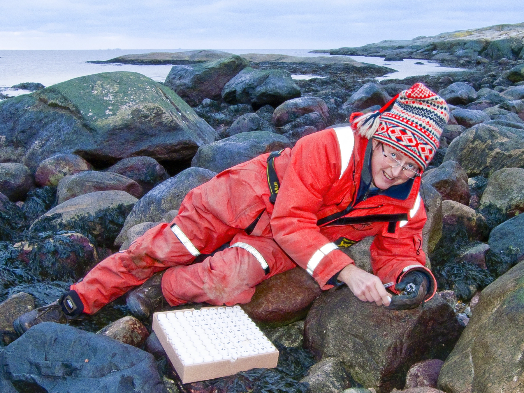 Kerstin Johannesson lies on a rocky outcrop along the coast.