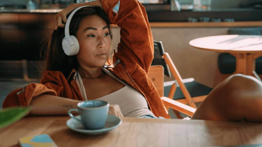 Mulher sentada em uma cadeira usando o JBL Tune 520BT