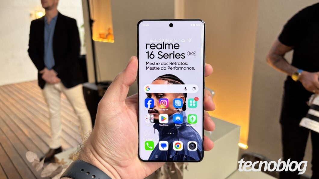 Celular na mão, mostrando a tela inicial do Android