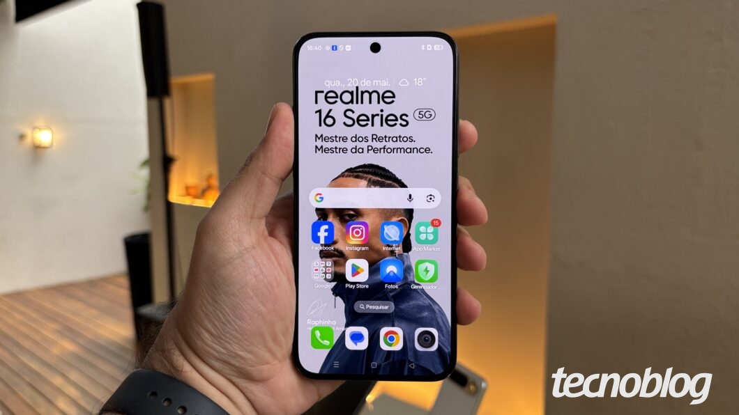 Celular na mão, mostrando a tela inicial do Android